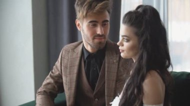 Kanepede oturan genç bir çiftin portresi.