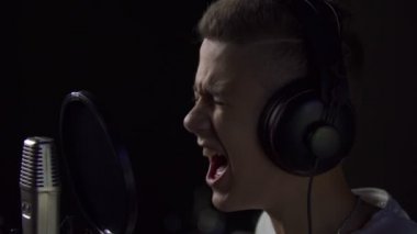 Çocuk mikrofona şarkı söylüyor.