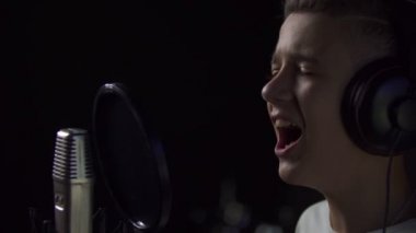 Çocuk mikrofona şarkı söylüyor.