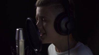 Çocuk mikrofona şarkı söylüyor.