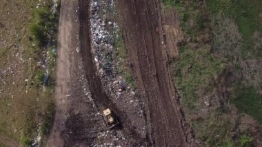 Buldozer çöplükte çalışıyor.