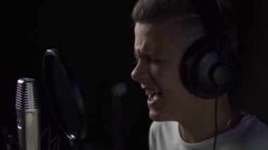 Çocuk mikrofona şarkı söylüyor.