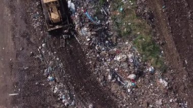 Buldozer çöplükte çalışıyor.