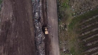Buldozer çöplükte çalışıyor.