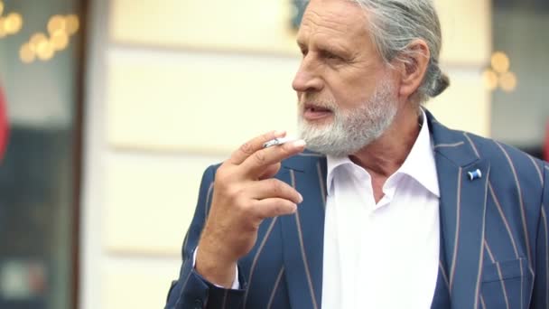 Un anciano fuma un cigarrillo — Vídeos de Stock