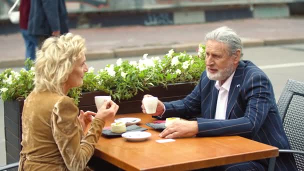 Bejaarde echtpaar zit aan tafel — Stockvideo