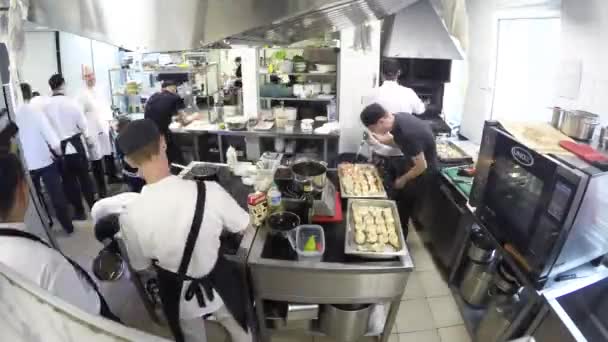 Temps écoulé de l'équipe occupée de chefs préparant la nourriture dans une cuisine commerciale — Video