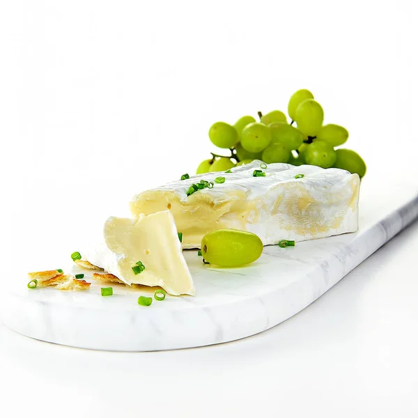 Queijo Brie Francês Com Uvas Brancas Atirado Contra Fundo Branco — Fotografia de Stock