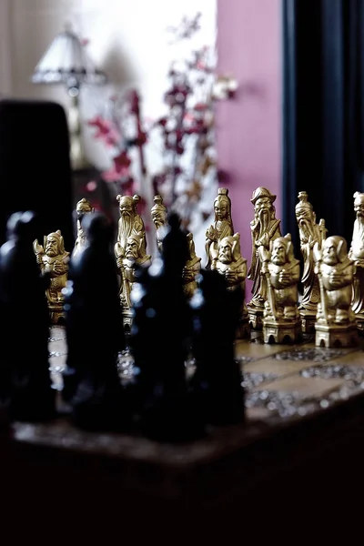 Luxury Chinese chess pieces. Dark, creatively lit styled image with differential focus. Concept image for business strategy, competition, relaxation, recreation and mental agility.