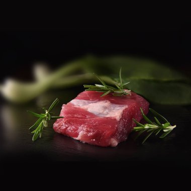 Siyah bir arka plan karşı atış rosemary ile ızgara için hazırlanan vahşi domuz ham fileto. Kopya alanı.