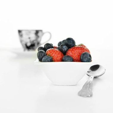 Bir kavram görüntü için sağlıklı beslenme, sağlıklı kahvaltı. Beyaz bir arka plan kopya alanı için konaklama ile çilek ve yaban mersini vurdu.