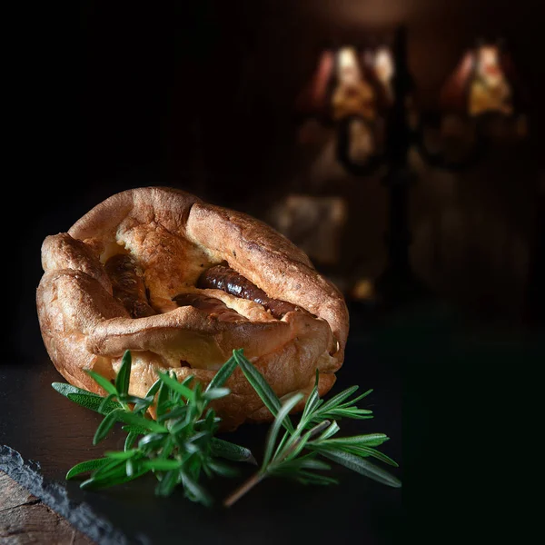 传统的英国蟾蜍菜在洞烤约克郡布丁与嵌入猪肉香肠与迷迭香装饰拍摄与复制空间的乡村背景 — 图库照片