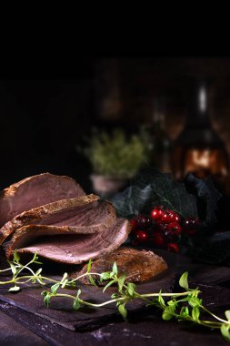 Sliced prime roast beef ready for serving shot against a festive and dark background with copy space. clipart