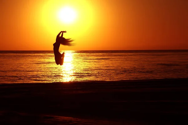 Silhouetten eines Mädchens, das bei Sonnenuntergang springt. — Stockfoto