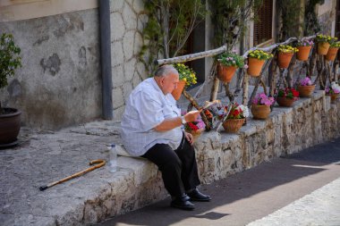 Valldemossa, Mallorca, Balearic Islands, İspanya - 21 Temmuz 2013: oturan biri yerel bir gazete okuyor.