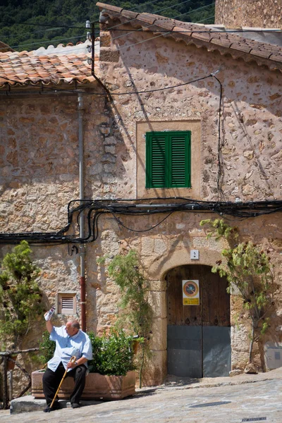Valldemossa, Mallorca, Balearic Islands, İspanya - 21 Temmuz 2013: oturan biri yerel bir gazete okuyor.