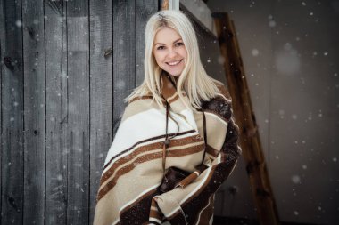 Bir ahşap duvar arka plan üzerinde gülümseyen bir vintage fotoğraf makinesi ile güzel sarışın kız