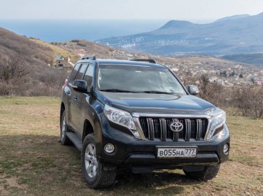 Alushta, Kırım Cumhuriyeti - Mart 23, 2019: Siyah off-road araba Toyota Land Cruiser Prado doğada park