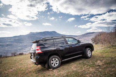 Alushta, Kırım Cumhuriyeti - Mart 23, 2019: Siyah off-road araba Toyota Land Cruiser Prado doğada park