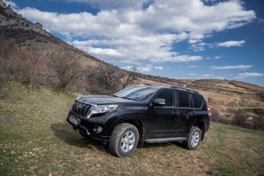 Alushta, Kırım Cumhuriyeti - Mart 23, 2019: Siyah off-road araba Toyota Land Cruiser Prado doğada park