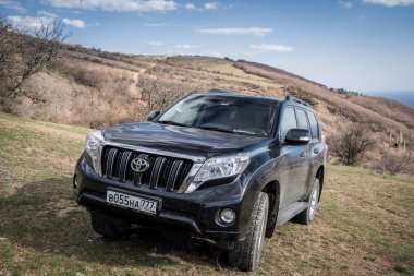 Alushta, Kırım Cumhuriyeti - Mart 23, 2019: Siyah off-road araba Toyota Land Cruiser Prado doğada park