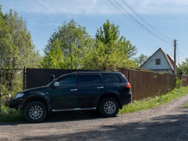 Siyah Mitsubishi Pajero Spor araba bir cou çit yakınında park