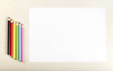 Renkli boya kalemi ve beyaz tahta arka plan üzerinde beyaz kağıdın