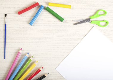 Okul çerçeve ve beyaz kağıt beyaz tahta üzerinde boş yüzeyli malzemeleri. Hamuru, tebeşir, kalemtıraş, fırça, makas, boya kalemi ve silgi.