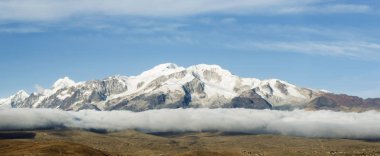 Zirvenin altında bulutlar ile Yüksek dağ panoramik manzara