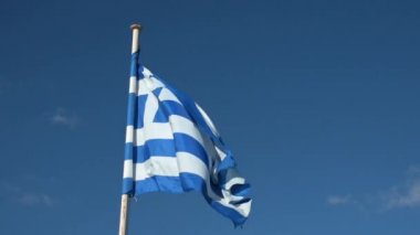 Yunan bayrağı sallayarak üzerinde mavi arka plan