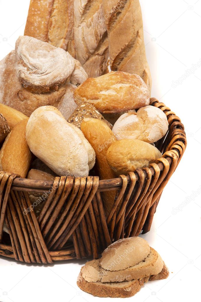 Fresh Assortment of several baked bread varieties inside a wicker basket.