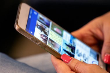 Sosyal medya kontrol etmek için bir cep telefonu kullanan bir kız görünümünü kapat.
