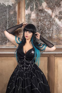 Karanlık bir görünüm üzerinde terk edilmiş bir Saray eski duvar resimleri ile Gotik kız giyinmiş.