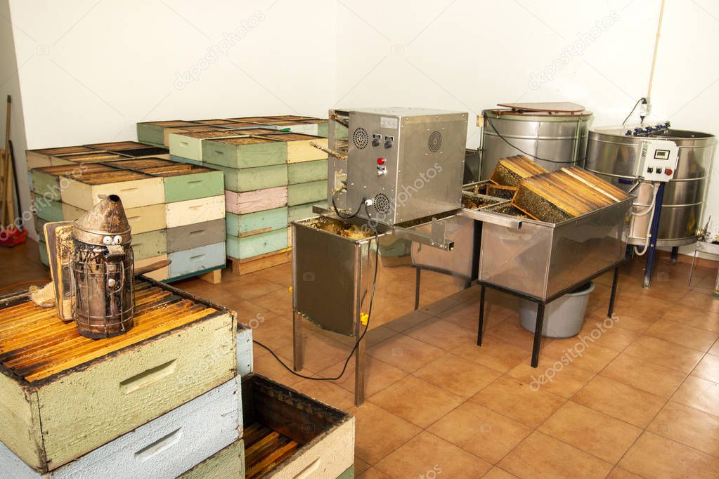 Interior view of beekeeper honey production facility with specific machinery and honeycombs.