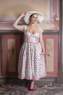 Beyaz elbise ve kırmızı çiçekler ve şapka ile bir kırsal genç bayan kadın görünümünü üzerinde terk edilmiş bir Saray eski duvar resimleri ile.