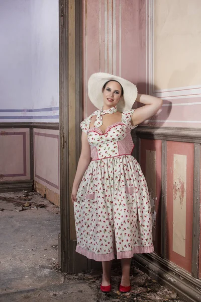 View of a countryside young lady woman with white dress and red flowers and hat on a abandoned palace with old mural paintings.