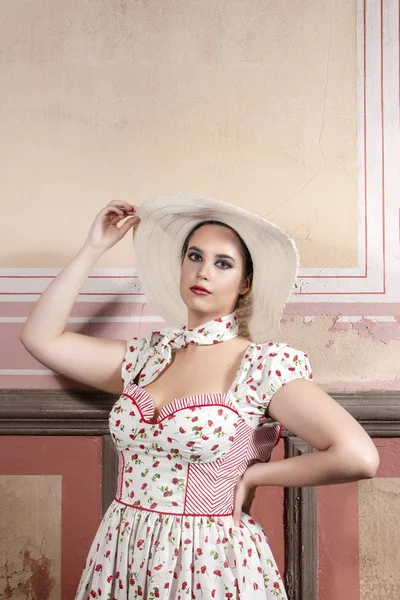 View of a countryside young lady woman with white dress and red flowers and hat on a abandoned palace with old mural paintings.