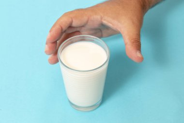 mavi bir arka plan üzerinde süt el kapmak.