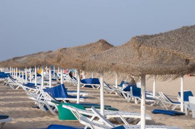 Sandalye recliners Fuseta Portekiz Algarve bölgesinde tarih ile plaj şemsiyeleri.