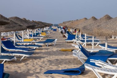 Sandalye recliners Fuseta Portekiz Algarve bölgesinde tarih ile plaj şemsiyeleri.