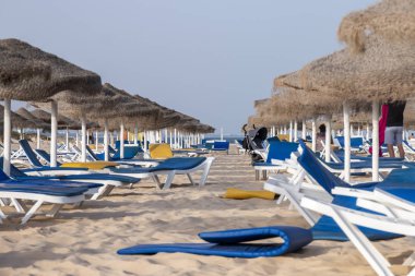 Sandalye recliners Fuseta Portekiz Algarve bölgesinde tarih ile plaj şemsiyeleri.