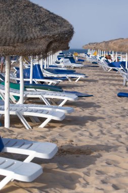 Sandalye recliners Fuseta Portekiz Algarve bölgesinde tarih ile plaj şemsiyeleri.