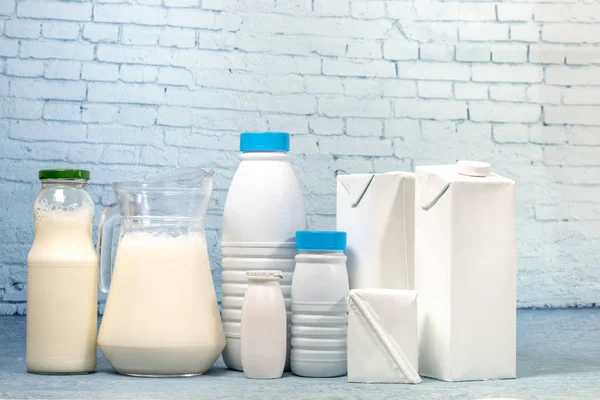 Mix Van Melkflessen Pakket Geïsoleerd Een Achtergrond Van Blauwe Baksteen — Stockfoto