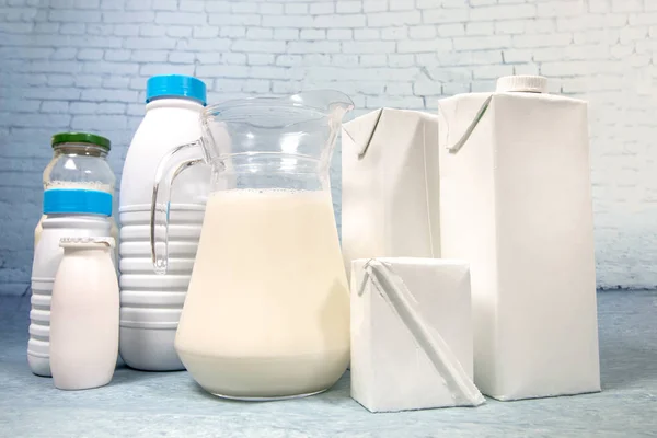 Mix of milk bottles and package isolated on a blue brick background.