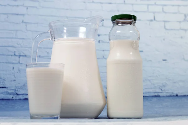 Mix of milk containers isolated on a blue brick background.