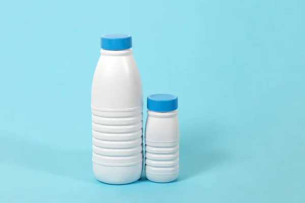 Volledige Plastic Flessen Van Melk Geïsoleerd Een Blauwe Achtergrond — Stockfoto
