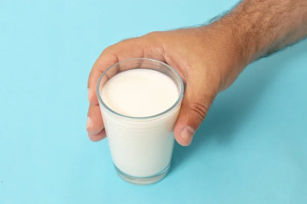 Mano Agarra Vaso Leche Sobre Fondo Azul —  Fotos de Stock