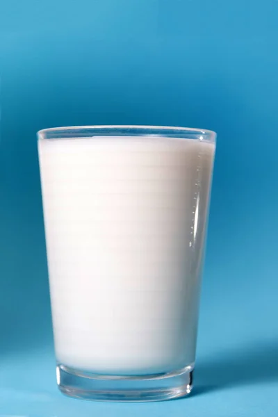 青色の背景に分離したミルクの完全なガラス — ストック写真