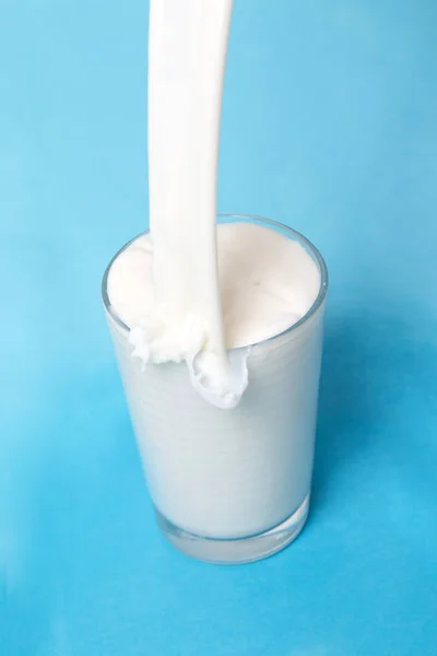 Gieten Melk Glas Geïsoleerd Een Blauwe Achtergrond — Stockfoto