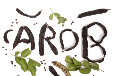 beyaz bir arka plan üzerinde izole Keçiboynuzu Meyve kabukları ile yapılan keçiboynuzu kelime.